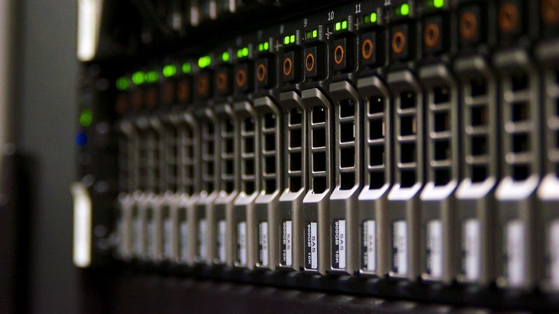 Front eines Serverschranks im Dunkeln, eine Reihe grüner Statusleuchten