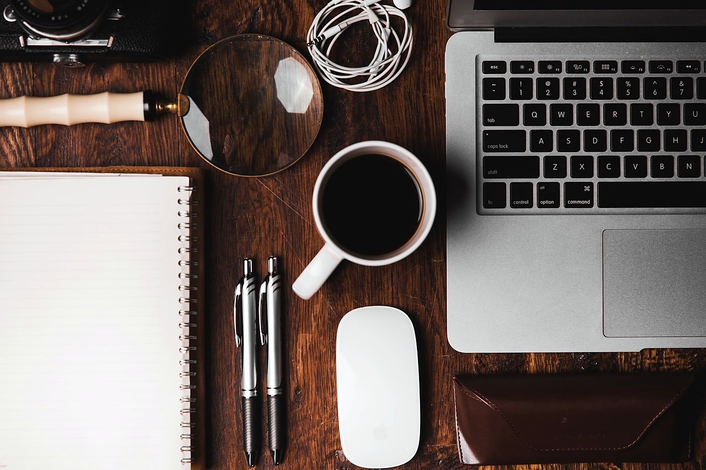 Arbeitsplatz mit Notebook, Notizen und Unterlagen auf dem Schreibtisch